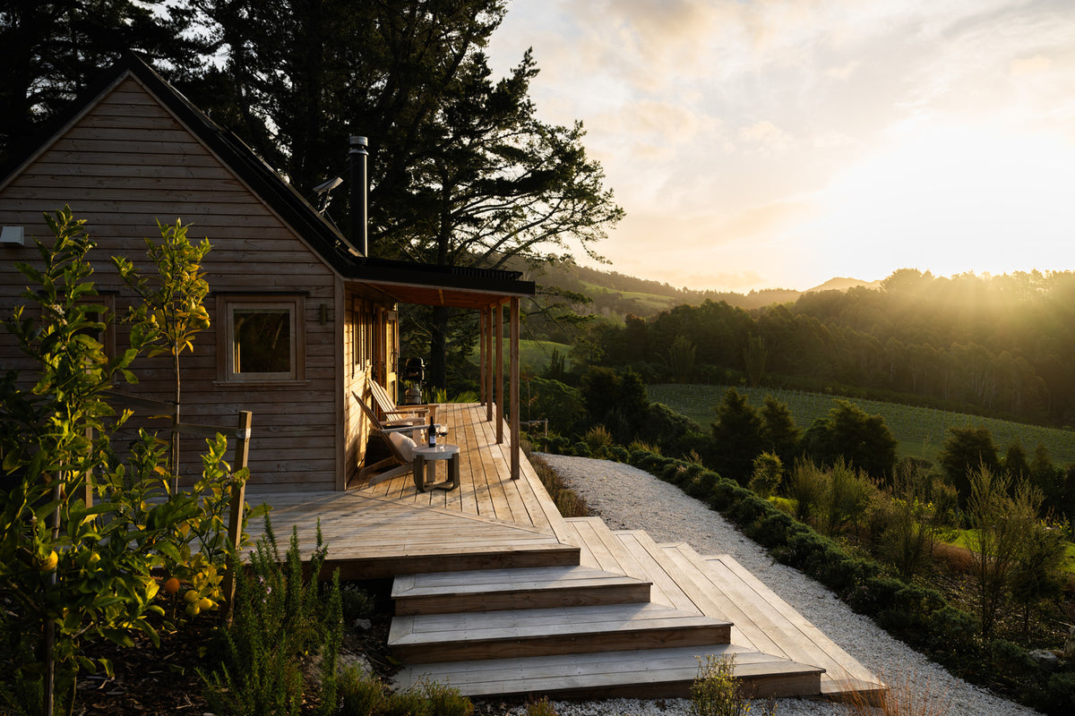 Paroa Bay off-grid cabin and deck among the vines
