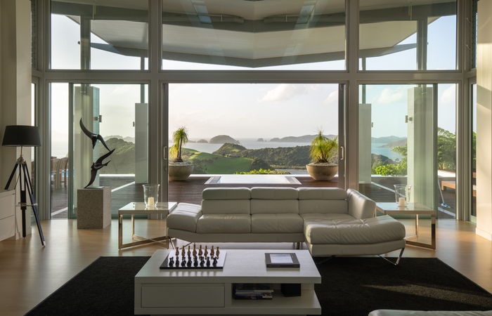 Tarāpunga Villa lounge opening onto the pool and coastal view